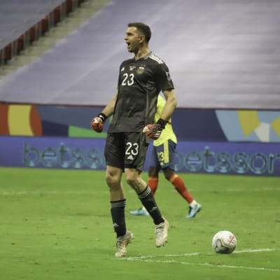 Emiliano Martinez hoppar och jublar efter en straffräddning. 