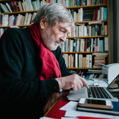 Claes Andersson tietokoneen ääressä.