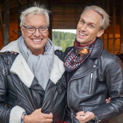 Christoffer och Lars-Åke står i ett fähus och ler mot kameran.