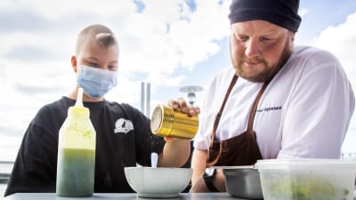barn lagar mat tillsammans med en kock