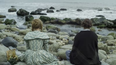 Charlotte (Saoirse Ronan) och Mary Anning (Kate Winslet) sitter på en strand och ser ut över havet.