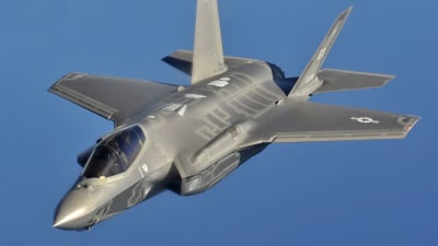 F-35A -hävittäjä lentää sinistä taivasta vasten.