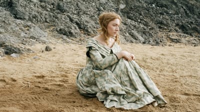Charlotte (Saoirse Ronan) sitter på en strand och ser allvarlig ut.