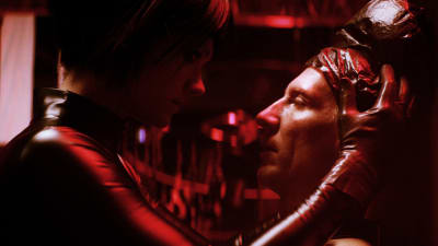 Mona (Krista Kosonen) håller om Juhas (Pekka Strang) huvud i ett mörkt källarutrymme.