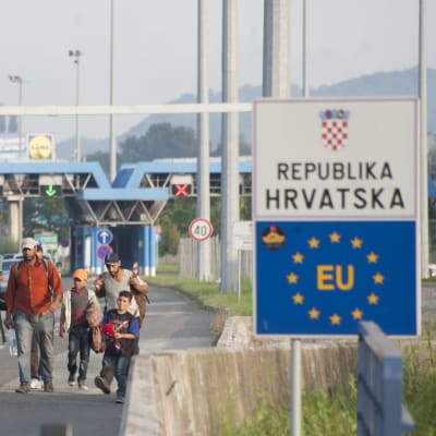 En grupp människor går från Kroatiens gränsövergång till Slovenien 