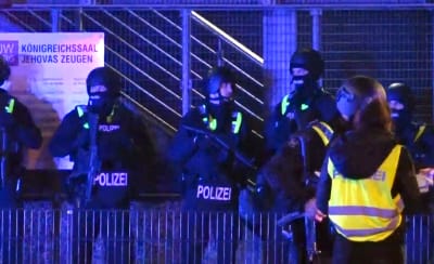Poliser spärrar av en byggnad efter masskjutning.
