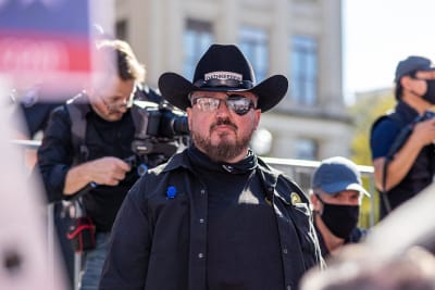 Stewart Rhodes, med cowboyhatt på huvudet och en lapp för vänster öga, ser rakt in i kameran.