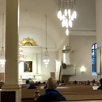 Fåtal kyrkobesökare i Kuopio domkyrka, bilden tagen inne i domkyrkan. 