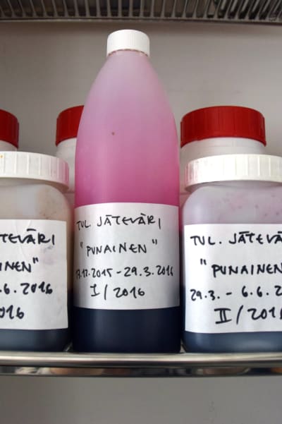 Flaskor med överbliven färg från digital tygtrycksmaskin. På etiketter text, vilken färg det är frågan om och datum.