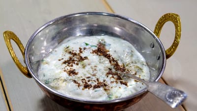En skål med Indisk sås med yoghurt och gurka smaksatt med mynta.