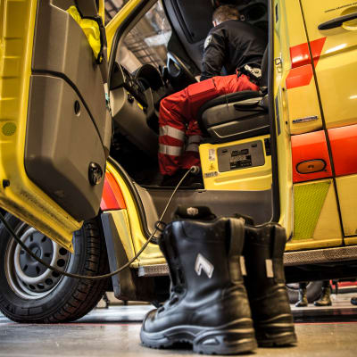 Kengät pelastuslaitoksen lattialla ambulanssin vieressä