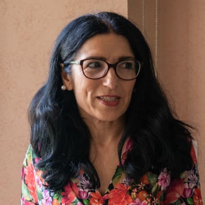 Amineh Kakabaveh står vid ett fönster.