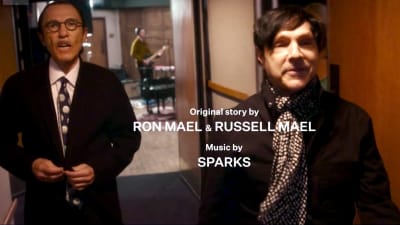 Sparks astelee käytävällä, kuva elokuvasta Annette, kuvan päällä teksti ”Original story by Ron Mael & Russell Mael, music by Sparks”.