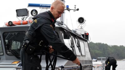 Sjöbevakare Kristian Ijäs kastar loss medan han står på gränsbevakningens båt.
