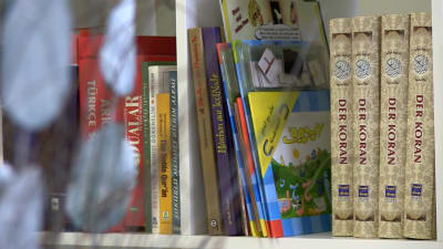 Tyskspråkiga Koranen och andra böcker i en bokhylla.