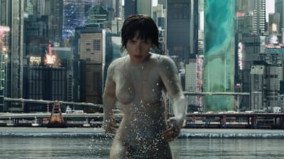 Major (Scarlett Johansson) springer i vatten, i bakgrunden skyskrapor.