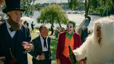 Maskerad i trädgården, William (Pål Sverre Hagen) utklädd till Lincoln, Jeppe (Jon Øygarden) har smoking, Adam (Simon J. Berger) är Jokern och Henrik (Tobias Santelmann) är en vit kanin. De ser alla glada ut och har glas och flaskor i händerna.