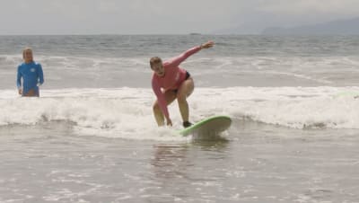 Au pairit sarjan Jenni harjoittelee surffaamista. 