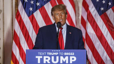 Trump talar bakom ett podium, i bakgrunden USA:S flagga.