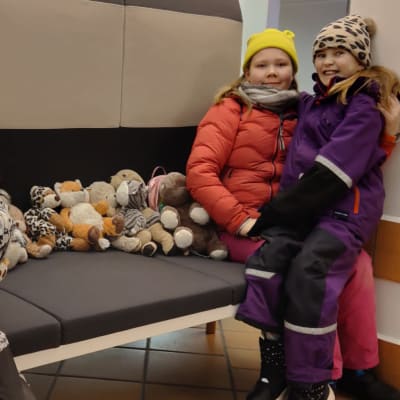 Espoolaiset Eino, Eevi ja Oona Sahanne pehmoleluineen Turun terminaalissa.