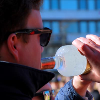 En studerande dricker direkt från en flaska. 
