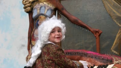 Liten pojke målad till Mozart vid piano