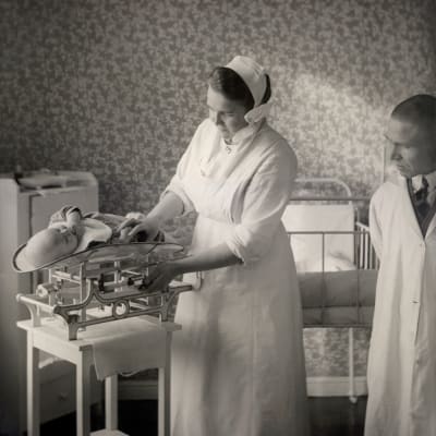 Arvo Ylppö övervakar då en nyfödd baby vägs, 1930-tal