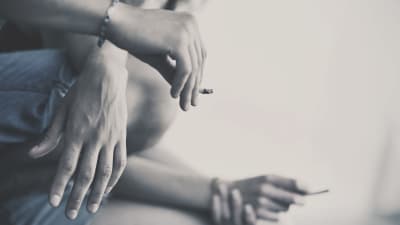 Händer som har cigaretter i handen.
