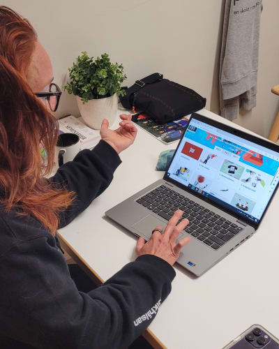 en kvinna visar sitt nya läromedel i modersmål på en datorskärm