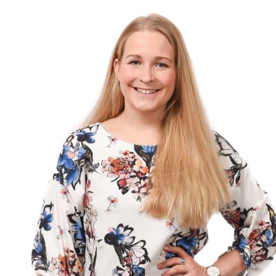 En ung kvinna med långt ljust hår skrattar mot kameran. Anita Westerholm leder Svensk Ungdom i Raseborg