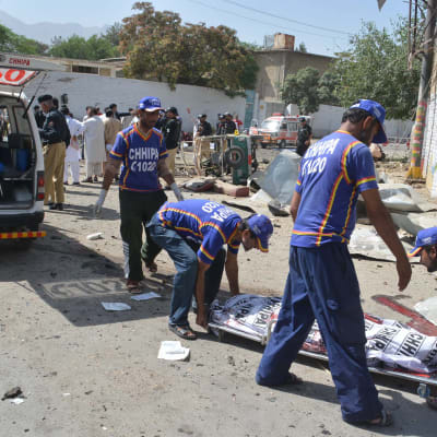 Räddningspersonal lyfter upp en bår till en ambulans i Quetta, Pakistan. 