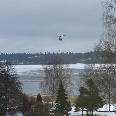 En helikopter ovanför Pojoviken i Österby en grå dag i januari.