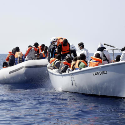 Flyktingar på Medelhavet plockas upp av den italienska kustbevakningen.