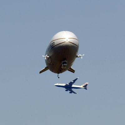 En zeppelinare bredvid ett flygplan.