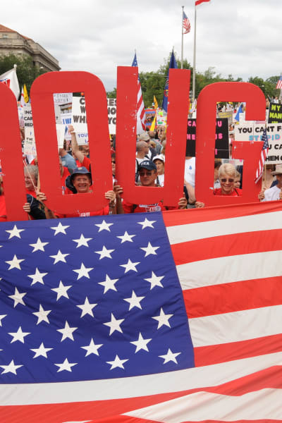 Tea Party-rörelsens demonstrerar mot Obamas häslovårdsreform och deltagare håller upp en stor text "det är nog" över Amerikas flagga.