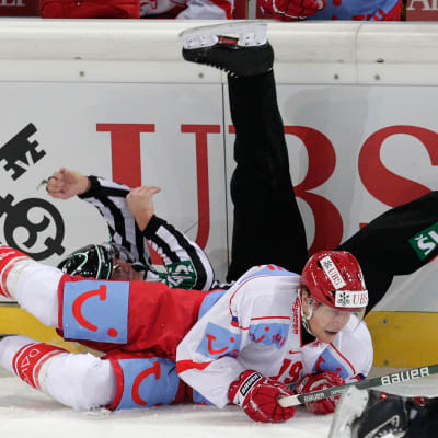Ishockeyspelare krockar med domare.