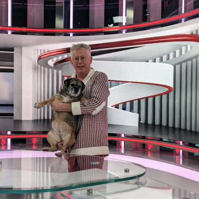 Pekka Pouta ja Sini-koira poseeraavat MTV:n uudessa uutistudiossa.