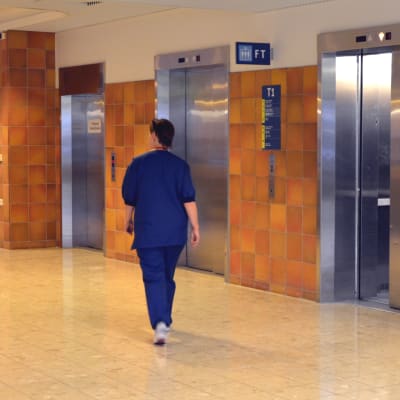 Sjukskötare går genom aulan i Vasa centralsjukhus på väg mot hissen