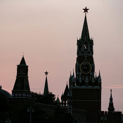 Kremlin tornit on kuvattu lähes mustana siluettina hieman punertavaa iltataivasta vasten.