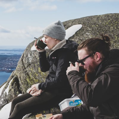 Elin och Andreas Söderlund sitter på Fløyfjellets topp och dricker kakao.