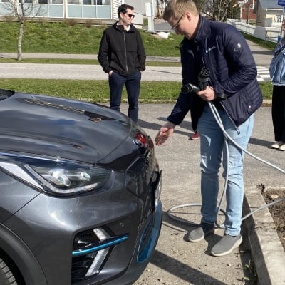 Person laddar elbilen.