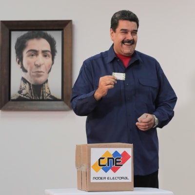 Nicolás Maduro lägger sin röst i söndagens lokalval, med ett porträtt på nationalhjälten Simón Bolívar i bakgrunden. 