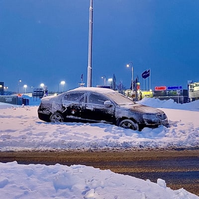 Bil som kört av vägen och fastnat mitt i  en snöhög.