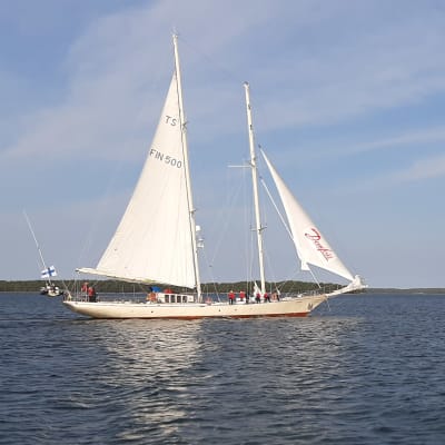 Skolfartyget Helena med vita segel möter en liten segelbåt.
