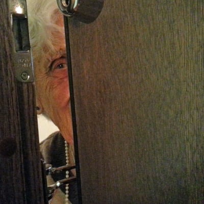Margaretha Berghell tittar ut genom dörrspringa.