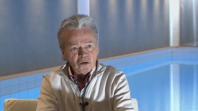 man sitter vid en inomhus simbassäng
