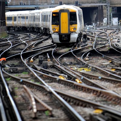 Brittiskt tåg anländer till en järnvägsstation i London.