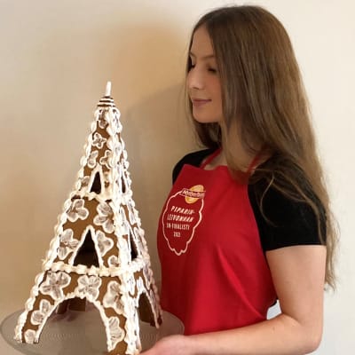 Anniina Hyvärinen pitelee lautasella piparitaikinasta leipomansa Eiffel-tornia.