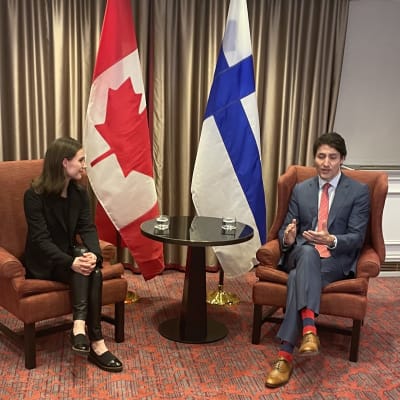 Sanna Marin ja Justin Trudeau tapasivat Brysselissä. Taustalla Suomen ja Kanadan liput. 
