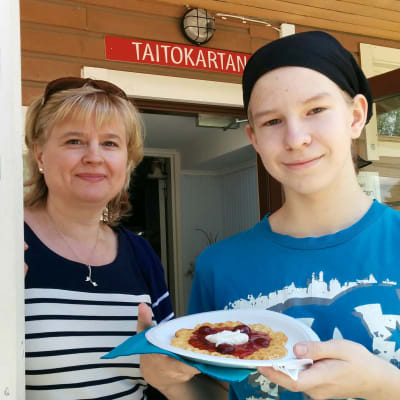 Pirjo Hämynen ja Santeri Heikkinen Taitokartanon kuistilla.